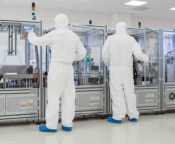 In the Manufacturing Facility Team of Scientist Wearing Sterile Protective Coverall Set's up / Programs Modern Industrial 3D Printer, High Precision Manufacture of Semiconductors under Process.